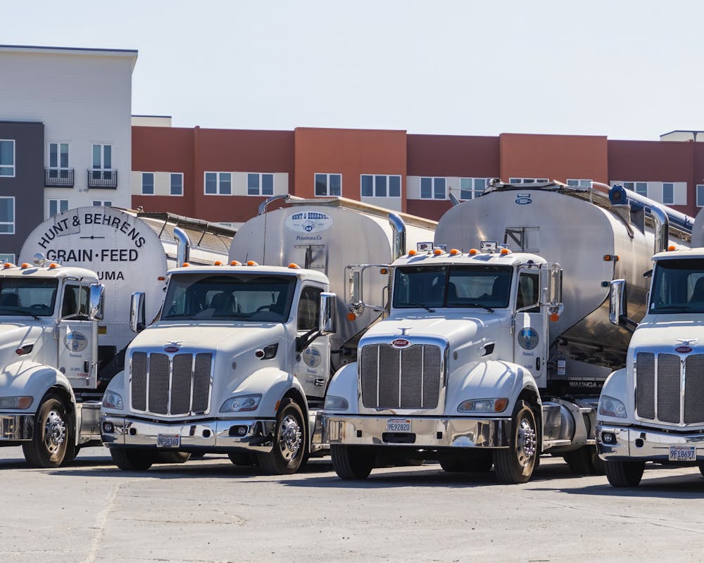 A row of identical trucks parked in a yard, valued unit by unit
